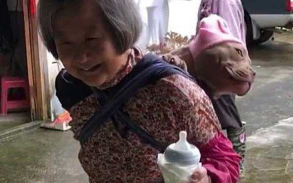 远看奶奶背上有个“孩子”，正好奇是哪家的，凑近后发现是汪
